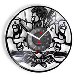 Horloge murale vintage en vinyle avec deux enseignes de barbier, un homme barbu de profil et la mention Barber Shop gravée pour décoration de salon de coiffure.