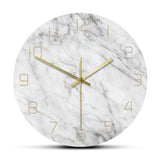 Horloge murale ronde minimaliste motif marbre blanc et gris avec chiffres et aiguilles dorés.