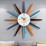 Horloge murale soleil design multicolore avec rayons géométriques et détails dorés salon