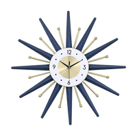 Horloge murale soleil design dorée et bleu canard avec rayons géométriques et tiges métalliques dans un salon moderne
