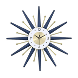 Horloge murale soleil design dorée et bleu canard avec rayons géométriques et tiges métalliques dans un salon moderne
