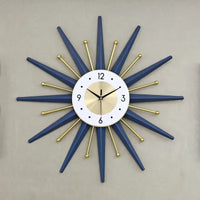 Horloge murale soleil design bleu nuit et dorée avec rayons géométriques au mur