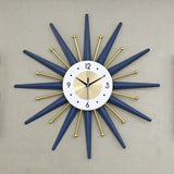 Horloge murale soleil design bleu nuit et dorée avec rayons géométriques au mur