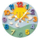 Horloge murale pour enfant avec un soleil jaune souriant au centre, ciel bleu, trois nuages blancs, lune, étoiles, collines vertes et chiffres multicolores