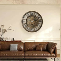 Horloge murale style industrielle rétro avec chiffres romains et engrenages apparents accrochée au mur d'un salon au-dessus d'un canapé en cuir