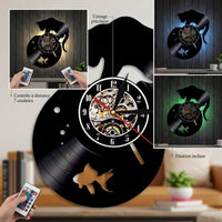 Infographie commerciale de l'horloge murale vinyle. Elle présente une vue détaillée du cadran avec des zooms sur le mécanisme (texte 'Usinage précision') et la télécommande incluse (texte 'Contrôle à distance 7 couleurs'). Une mise en situation dans un salon montre la télécommande en main et le texte 'Fixation incluse'.