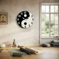 Horloge murale design yin yang zen installée dans une salle de yoga et de méditation lumineuse.