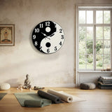 Horloge murale design yin yang zen installée dans une salle de yoga et de méditation lumineuse.