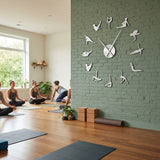 Horloge murale design yoga argent sur mur de briques vert dans un studio de yoga avec des pratiquantes