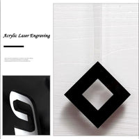 lazer acrylique sur le balancier du pendule de l'Horloge murale rectangulaire au design géométrique moderne avec panneaux en acrylique noir, chiffres épurés et balancier suspendu pour salon design.