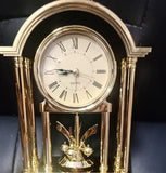 Véritable mini horloge dorée à pendule rotatif, détail du cadran à chiffres romains et mouvement quartz de précision.