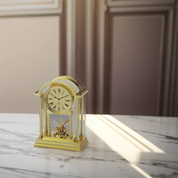 Véritable horloge miniature dorée sur table en marbre, lumineuse décoration classique avec cadran romain.