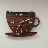 Avis client en photo réelle d'une pendule murale en bois foncé en forme de tasse de café accrochée sur un mur blanc