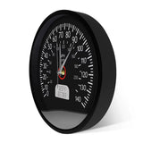 vue de coté de l'Horloge murale ronde au design de compteur de vitesse automobile, dotée d'un fond noir mat, de chiffres et graduations blancs allant de 0 à 140, des mentions « MPH » et « km/h », d'un faux écran numérique à cristaux liquides affichant des chiffres gris, ainsi que d'aiguilles blanches et d'un axe central cerclé de rouge