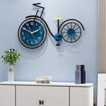 grande horloge murale design contemporaine en forme de vélo de diamètre 60 cm dans au dessus d'une armoire commode