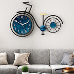 grande horloge murale design contemporaine en forme de vélo de diamètre 60 cm dans le salon au dessus du canapé