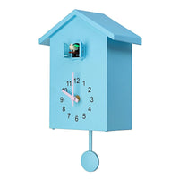 Horloge murale coucou moderne bleue pastel avec aiguilles roses et oiseau sortant de sa niche