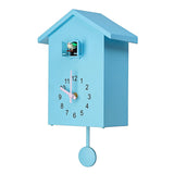 Horloge murale coucou moderne bleue pastel avec aiguilles roses et oiseau sortant de sa niche