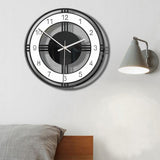 Horloge murale design contemporain noir et blanc à cadran ajouré géométrique de 30 cm cahmabre au dessus du lit