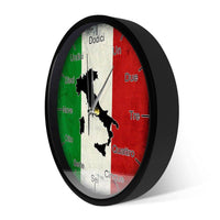 Vue de trois quarts d'une horloge murale ronde avec un cadre noir épais. Le cadran, visible en perspective, montre le drapeau italien, la carte noire de l'Italie et les heures écrites en toutes lettres en italien.