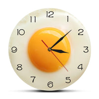Horloge murale design en forme d'œuf sur le plat avec cadran original pour décoration de cuisine.