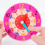 horloge montessori pour enfant rose entre mains